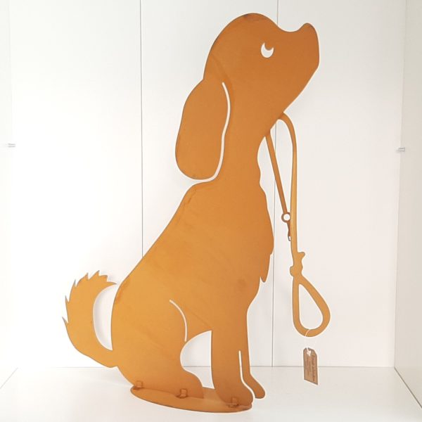 Schitterende, decoratieve metalen hond. Past in een mooie, industriële omgeving. Doordat het metaal een roest-kleur heeft, oogt het verweerd. De hond is staand neer te zetten door de ronde schijf (9cm) onderop het beeld. heeft deze afmetingen: L 40x b 9 x h 50 cm